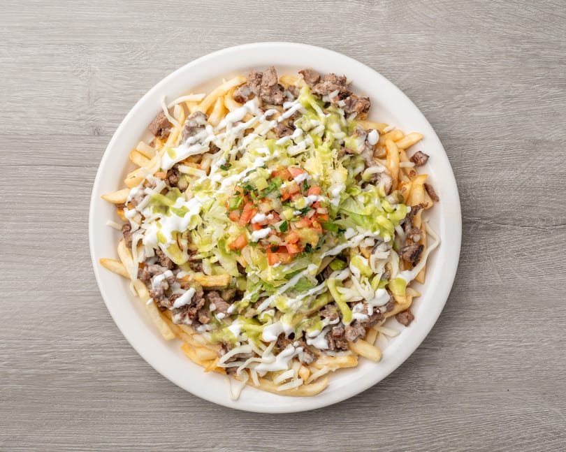 Carne asada fries topped with shredded cheese, sour cream, guacamole, and pico de gallo.